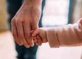 Baby holding a man's finger