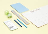Yellow background with calendar, stationary supplies, and a phone showing online sales information