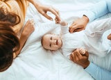 Mother and father playing with their baby