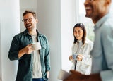 Group of colleagues sharing a coffee and laughing
