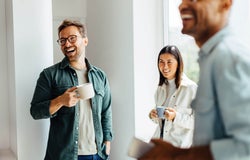 Group of colleagues sharing a coffee and laughing