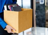 Woman carrying box of possessions out of an office
