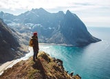 Man standing on cliff looking out to sea