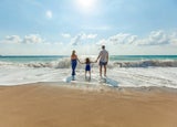 Family paddling in the sea at the beach
