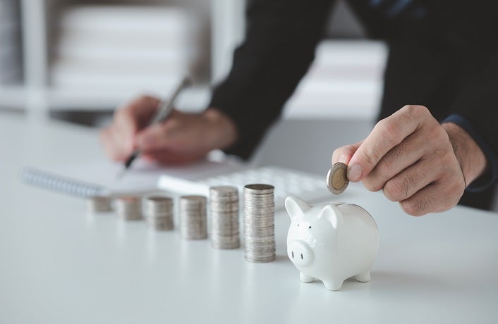 Person with pile of coins and piggy bank, money saving concept for future use and financial stability, salary management, personal finance, investment savings.